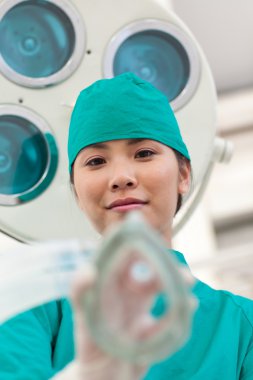 Young doctor applying oxygen mask to a patient clipart