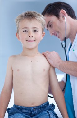 Smiling examinating a child with stethoscope clipart