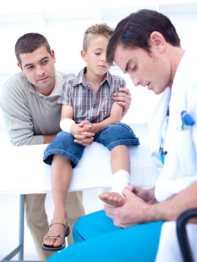 Doctor bandaging a patient's foot clipart