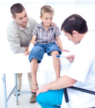 Doctor checking a patient reflexes clipart