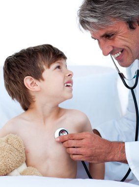 Mature male doctor checking little boy's pulse clipart