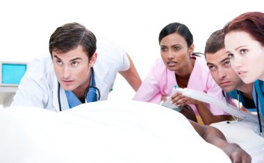 Confident medical team resuscitating a patient clipart