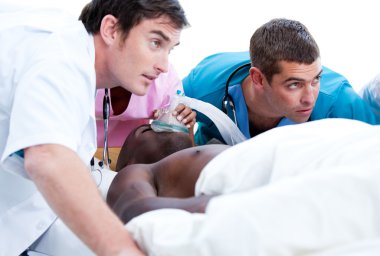 Concentrated medical team resuscitating a patient clipart