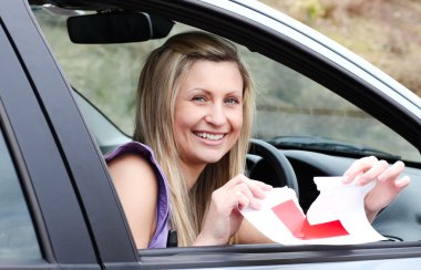 Jolly young female driver tearing up her L sign clipart