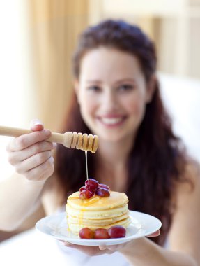 Woman holding pancakes with fruit and honey clipart