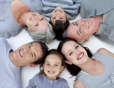 High angle of family lying on floor with heads together clipart