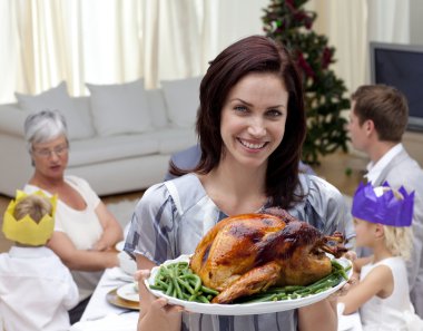 Woman showing Christmas turkey for family dinner clipart