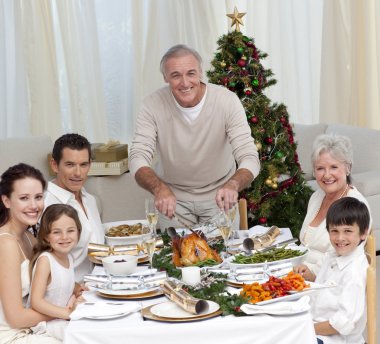 Grandfather cutting turkey for Christmas dinner clipart