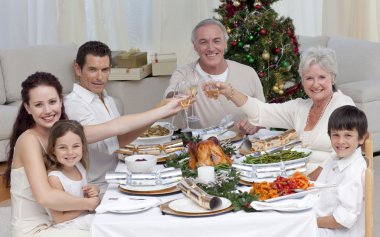 Family drinking a toast in a Christmas dinner clipart