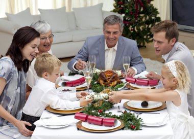 Children pulling a Christmas cracker at home clipart