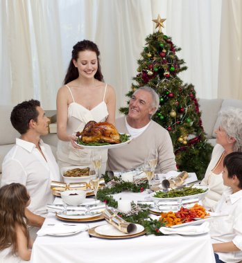 Mother showing turkey to her family for Christmas clipart