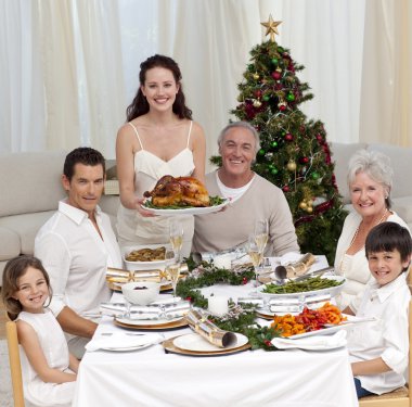 Family celebrating Christmas dinner with turkey clipart