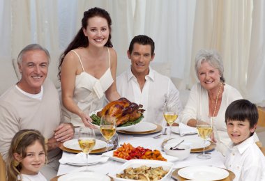 Family eating turkey in a dinner clipart