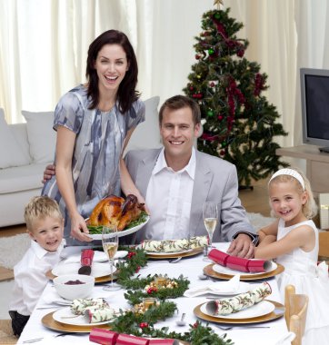 Parents and children celebrating Christmas dinner with turkey clipart