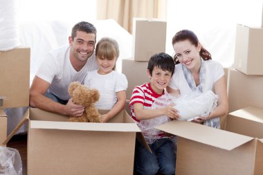 Family moving home with boxes around clipart