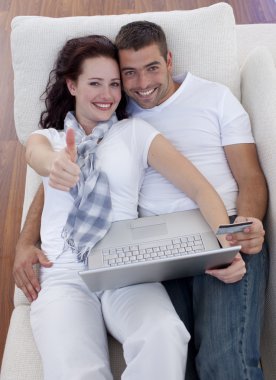 Couple buying online at home with thums up clipart