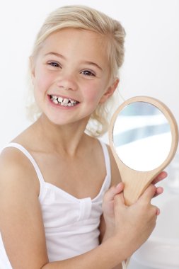 Little girl playing holding a mirror clipart