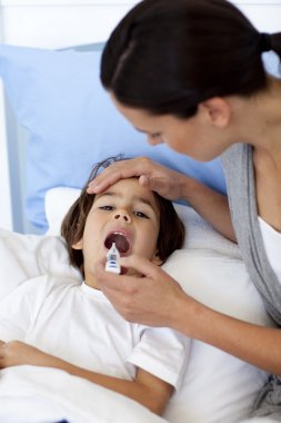 Close-up of mother taking her son's temperature with a thermomet clipart
