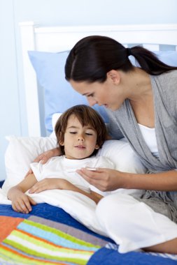 Mother taking her son's temperature clipart