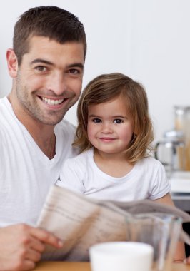 Smiling father reading a newspaper with his daughter clipart