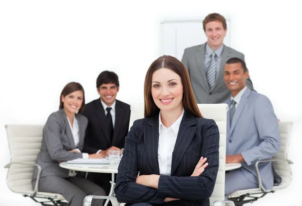 Charismatic female executive sitting in front of her team — Stock Photo, Image