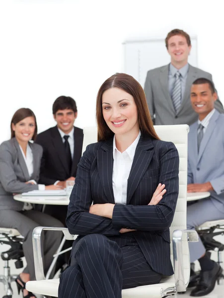 Mujer de negocios sonriente sentada frente a su equipo —  Fotos de Stock