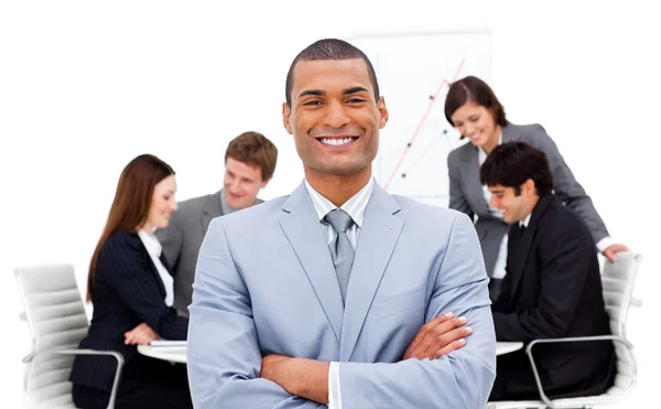 Ethnic businessman sitting in front of his team — Stock Photo, Image