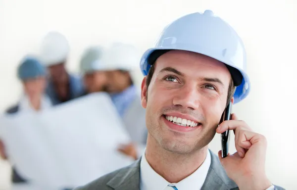 Telefon bir kask ile bir erkek arhitect üzerinde odaklanmak — Stok fotoğraf