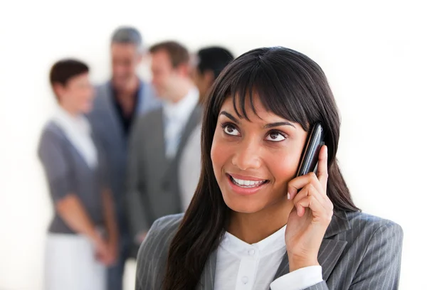 Etniska affärskvinna på telefon framför hennes team — Stockfoto