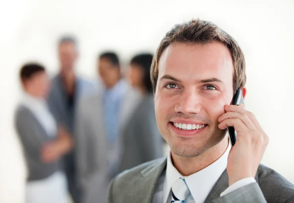 Young businessman on phone in front of his team — Stock Photo, Image