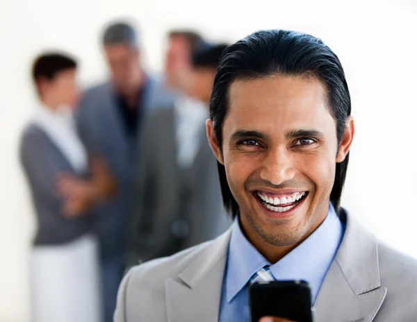 Cheerful ethnic businessman sending a text — Stock Photo, Image