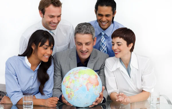 Lachende bedrijf op zoek op een terrestrische globe — Stockfoto