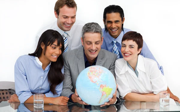 Een zakelijke groep weergegeven: diversiteit kijken naar een aardse glob — Stockfoto