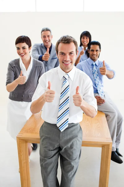 Equipe de negócios internacional afortunada com polegares para cima — Fotografia de Stock
