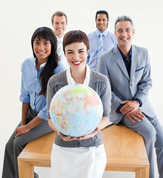 Glada multietniska företag innehar en terrestrial glob — Stockfoto
