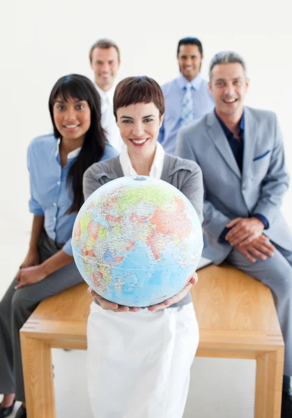 Sonriente equipo de negocios sosteniendo un globo terrestre —  Fotos de Stock