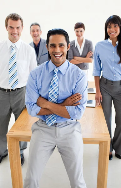 Smiling multi-ethnic Business partners standing around a table — Stock Photo, Image