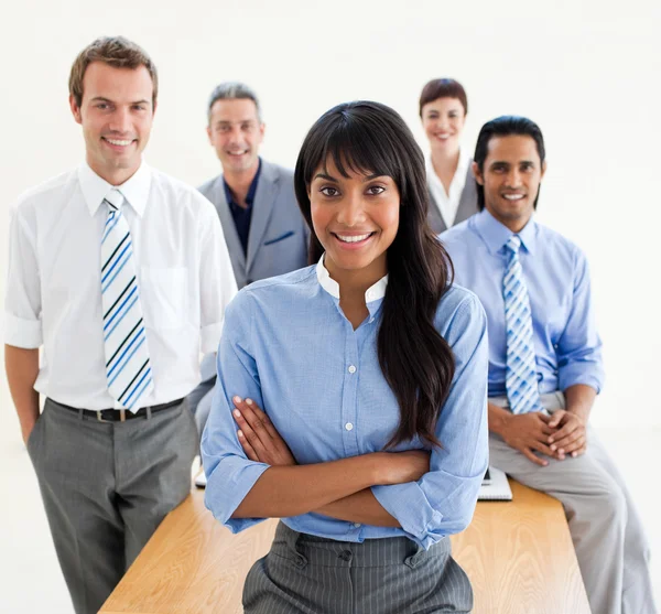 Glimlachende medewerkers staan rond een tabel — Stockfoto