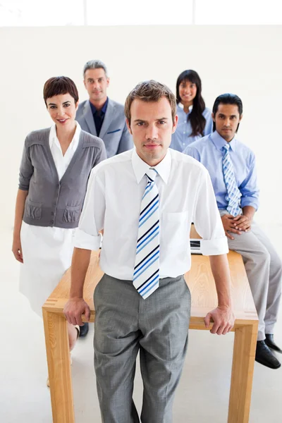 Multi-ethnic business team standing around a table — Stock Photo, Image