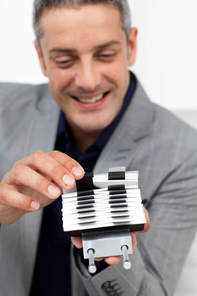 Charming businessman consulting a business card holder — Stock Photo, Image