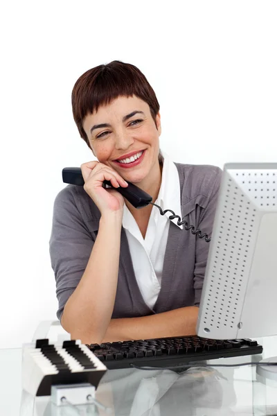 彼女の机で電話を保持してうれしそうな女性実業家 — ストック写真