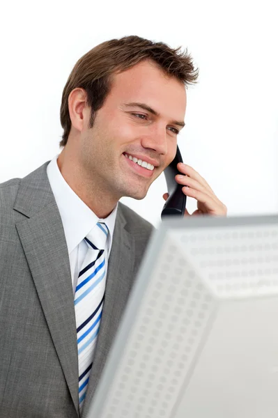 Charming businessman on phone at a computer — Stock Photo, Image