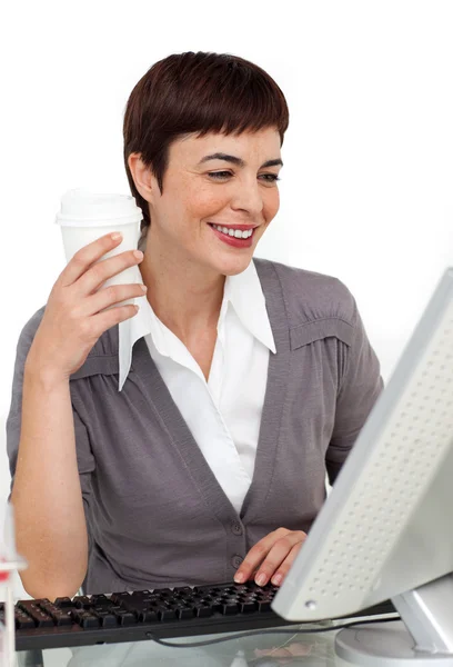 Vrouwelijke uitvoerend drinken een kopje koffie op haar Bureau — Stockfoto