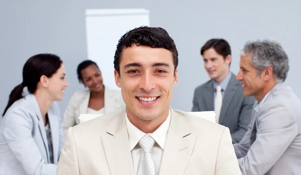 微笑着坐在他的团队在一次会议前的商人 — 图库照片