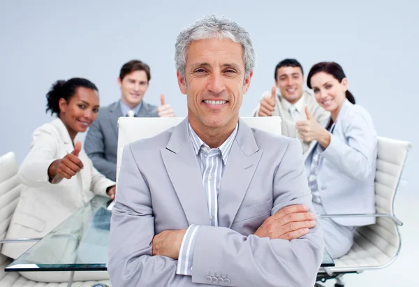 Glad affärsman ledande hans glada team med tummen — Stockfoto