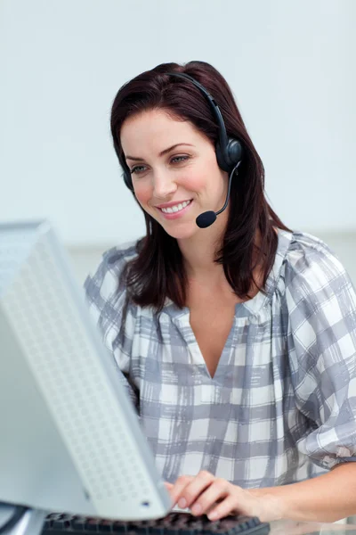 Charming businesswoman with headset on working at a computer — Stock Photo, Image