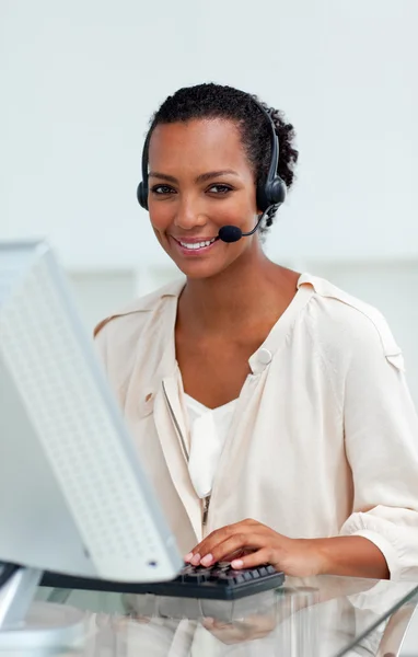 Afro-amerykański kobieta z zestawem słuchawkowym na pracy w obliczeń — Zdjęcie stockowe