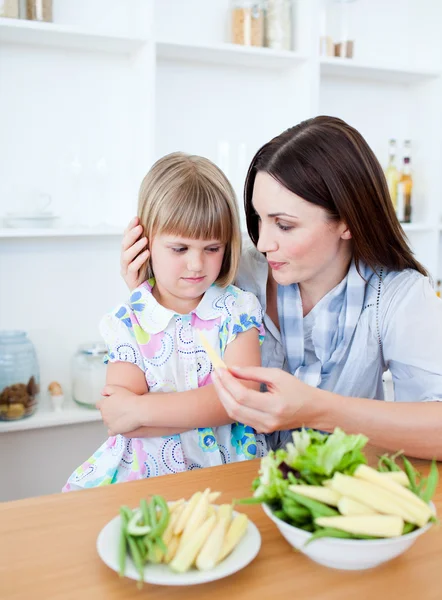 그녀의 어머니와 함께 야채를 먹는 짜증이 금발 소녀 — 스톡 사진