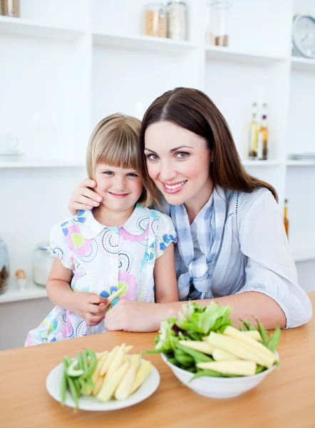 Schattig klein meisje eten van groenten met haar moeder — Stockfoto