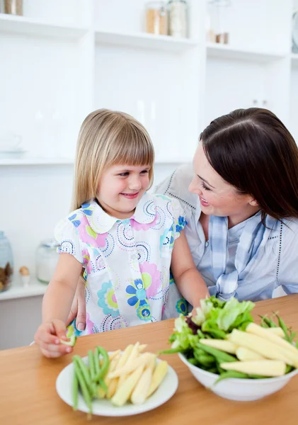 Aufmerksame Mutter und ihre Tochter essen Gemüse — Stockfoto